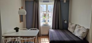 um pequeno quarto com uma mesa, uma mesa e uma janela em Hotel Udsigten Marstal em Marstal