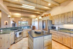 uma grande cozinha com armários de madeira e uma grande ilha em Taos Adobe Home with Mountain Views and Hot Tub! em Taos