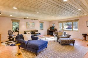 uma sala de estar com um sofá azul e cadeiras em Taos Adobe Home with Mountain Views and Hot Tub! em Taos