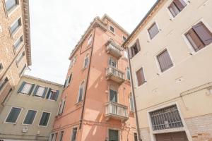 - un bâtiment en briques rouges avec un balcon dans l'établissement Casa Luna - vicino alla stazione dei treni, à Venise