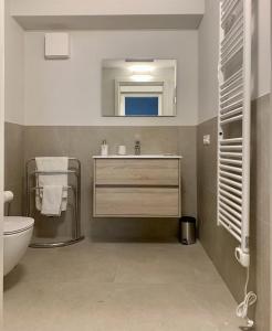 een badkamer met een wastafel, een toilet en een spiegel bij Panorama Loft Apartments in Stresa