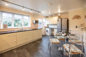 a kitchen with a table and a stainless steel refrigerator at 4 The Sandlings in Aldeburgh