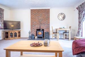 a living room with a table and a fireplace at 4 The Sandlings in Aldeburgh