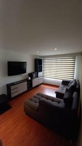 a living room with a couch and a flat screen tv at Hermoso departamento mejor ubicación Modelia Bta. in Bogotá