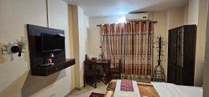 - une chambre avec un lit, une télévision et une table dans l'établissement Hotel Simara, à Pipara Simara
