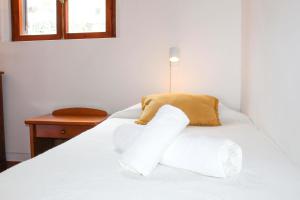 un letto bianco con cuscini bianchi sopra di Casa dos Magalhães a Vila do Porto
