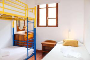 a bedroom with two bunk beds and a desk at Casa dos Magalhães in Vila do Porto