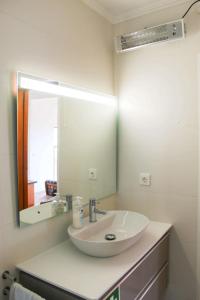 a bathroom with a sink and a mirror at Casa dos Magalhães in Vila do Porto +33 photos