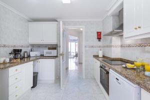 a white kitchen with white cabinets and appliances at Paseo del Mar in Aduanas