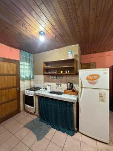 a kitchen with a white refrigerator and a sink at Alojamiento El Remanso in Puerto Iguazú