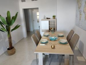 Un comedor con mesa y sillas de madera. en Mojácar beach increíbles vistas Arniel, en Mojácar