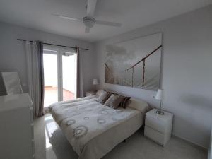 Un dormitorio con una cama grande con un cuadro en la pared. en Mojácar beach increíbles vistas Arniel, en Mojácar 21 fotos más
