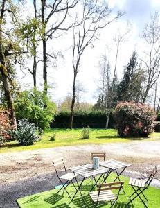 Saint-Aignan-Grand-LieuにあるAppartement proche de l'aéroport de Nantesの公園内のピクニックテーブルと椅子