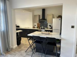 a kitchen with a table with chairs and a refrigerator at Ferrers House in Doncaster