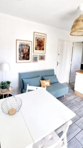 Appartement proche de l'aéroport de Nantes في Saint-Aignan-Grand-Lieu: غرفة معيشة مع أريكة زرقاء وطاولة
