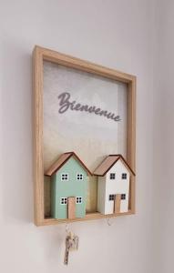 a picture of two houses in a wooden frame at Appartement proche de l'aéroport de Nantes in Saint-Aignan-Grand-Lieu