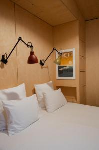a bedroom with a bed with white pillows and a lamp at Les Tilleuls Etretat in Étretat