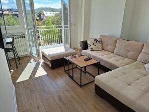 een woonkamer met een bank en een tafel bij Relax Lux apartment Nis in Niš