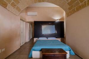 a bedroom with a bed with a blue comforter at Vico5 in Lecce