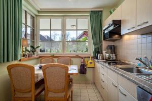 a kitchen with a table and chairs and a window at Claudis Seeland in Kressbronn am Bodensee