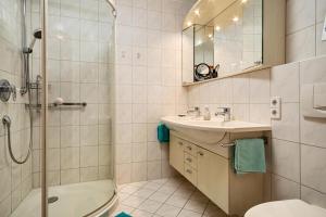 a bathroom with a shower toilet and a sink at Claudis Seeland in Kressbronn am Bodensee +16 photos