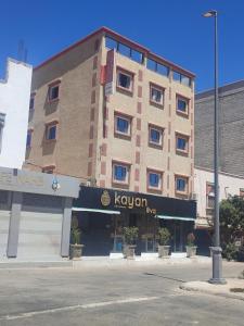 een hotel op de hoek van een straat met een gebouw bij Résidence hôtelière Nour in Dakhla