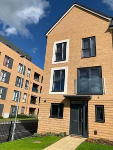 a brick apartment building with a black door at Brand New Entire 4 Bed House Multiple Free Parking Early Check-in Late Check- Out Allowed in South Ockendon