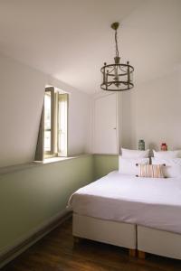 a bedroom with a bed and a window and a chandelier at Les Tilleuls Etretat in Étretat