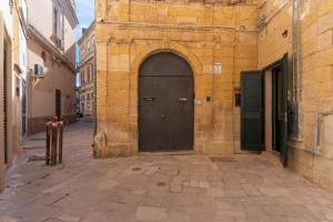 a brown door in a stone building with a street at Vico5 in Lecce