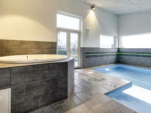 baño grande con bañera y piscina en 16 person holiday home in V ggerl se en Bøtø By