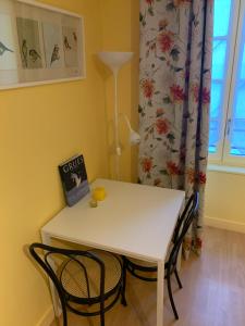 a white table and chairs in a room with a window at A MARIE ET GABRIEL in L'Ile-Bouchard