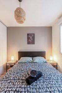 1 cama en un dormitorio con 2 mesitas de noche y 2 lámparas en Cosy appartement - Parking Privé Gratuit en Chambéry
