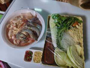 einen Tisch mit einer Schüssel Suppe und einem Teller Essen in der Unterkunft Riverhilk khaoyai in Ban Bung Toei
