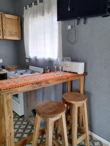 una cocina con una barra con copas de vino. en Sankofa Cabañas en Yacanto