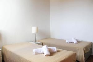 a room with two beds with towels on them at Casa dos Magalhães in Vila do Porto