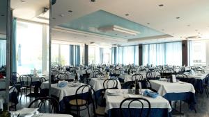 アルバ・アドリアティカにあるHotel Kingの白いテーブルと椅子が備わる宴会場