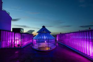 a bird cage with purple lights on a fence at Hotel Las Tres Campanas in Badajoz