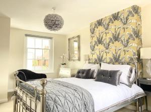 una camera da letto con un grande letto e carta da parati floreale di Elegant, Luxury Family Apartment! Marlow Town Centre, Walk to Pubs a Buckinghamshire
