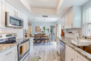 a kitchen with white cabinets and a dining room at BayCation in Tampa