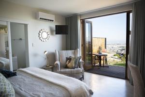a bedroom with a bed and a sliding glass door at 43 On Sandstone in Somerset West