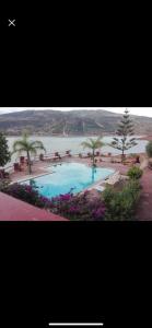 a large swimming pool next to a body of water at Villa arri atlas in Bine el Ouidane