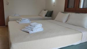 two beds with towels on them in a room at Maria Apartments in Pefki