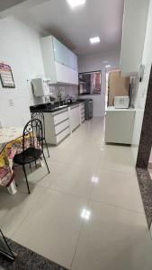 a kitchen with white cabinets and a white floor at Casa próximo do aeroporto de Brasília in Brasilia