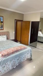 1 dormitorio con 1 cama y algunos armarios de madera en Casa próximo do aeroporto de Brasília en Brasilia