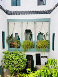 un edificio blanco con ventanas con plantas. en Riad 11 Zitoune en Marrakech