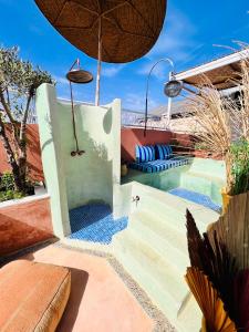 a resort with a pool and an umbrella at Riad 11 Zitoune in Marrakech