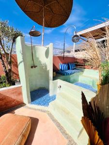 a resort with a pool and an umbrella at Riad 11 Zitoune in Marrakesh