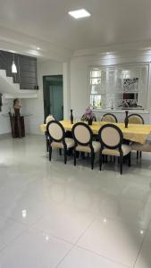 Casa próximo do aeroporto de Brasília في برازيليا: غرفة طعام مع طاولة وكراسي خشبية