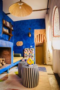een kamer met een stoel en een blauwe muur bij Riad 11 Zitoune in Marrakesh