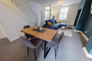 a living room with a table and a blue couch at Stockton House in Stockton-on-Tees